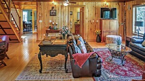 A spacious living room with a wooden ceiling, a fireplace, a dining area, and a staircase. - Large Mountain Lodge, Pet Friendly, w/ Hot Tub, and Sports Bar/Game Room. (Ripton)