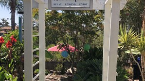 A garden with a pergola labeled "Beach Rules" and a pathway. - Private Enchanted Garden (Oceanside)