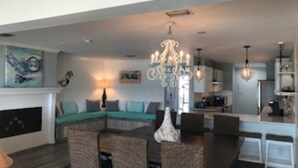 A modern living room with a sectional sofa, dining area, and kitchen.
