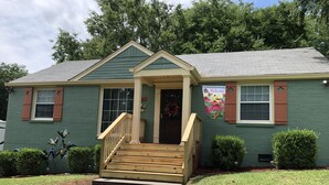 A green house with a front porch, a welcome banner, and a number '12' sign. - 5* Cutie Has It All! Just Bring Family & Friends! (Nashville)