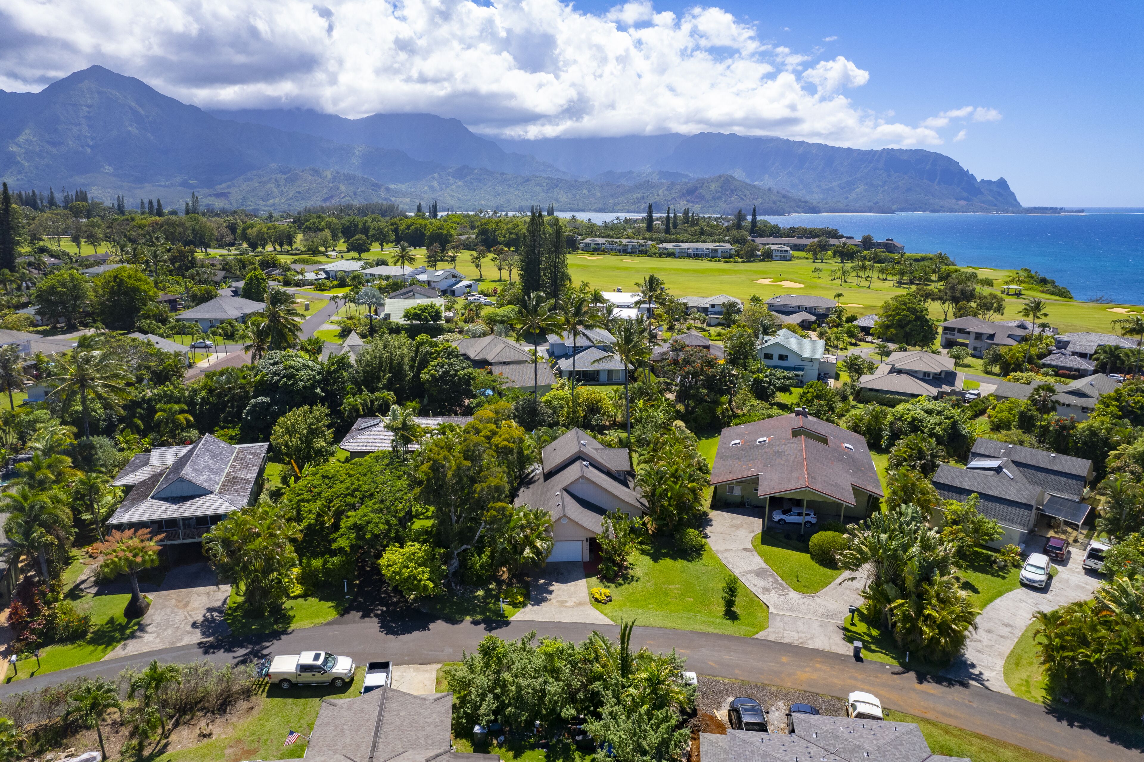 Un barrio residencial con casas, un campo de golf y vistas al océano y las montañas.
