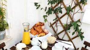 Taula preparada per esmorzar, amb pastissos, una gerra de suc d'aranja i menjar per esmorzar.