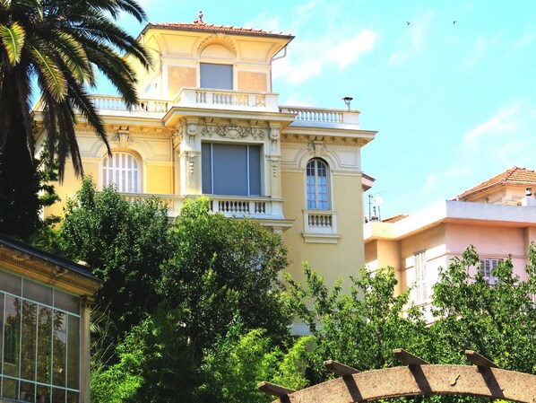 A multi-story building with classical architecture, featuring balconies and large windows.