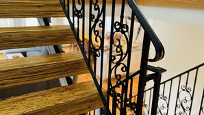 Una scala in legno con elaborate ringhiere in metallo nero.