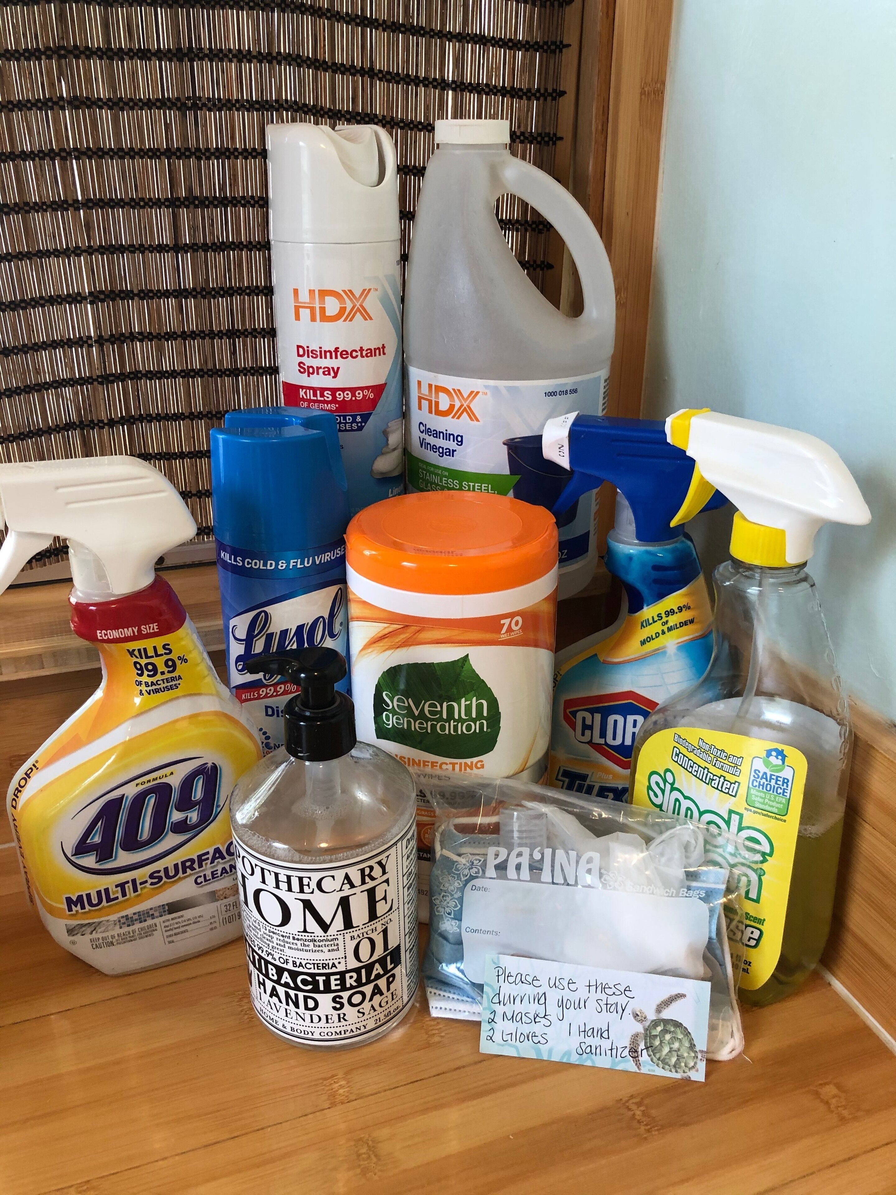 A variety of cleaning supplies including disinfectant spray, cleaning vinegar, multi-surface cleaner, hand soap, and other cleaning products.