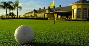 A golf ball on a green with a flag in the background. - 8BR ULTIMATE LUXURY, PRIVATE POOL & SPA, HOME THEATRE. CLOSE TO DISNEY, GOLF (Davenport)