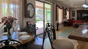 A dining area with a table set for four, a vase of flowers, and a large mirror on the wall. - SUNLAND VILLA - High End resort with heated pool/spa, few minutes to golf course (Goodyear)