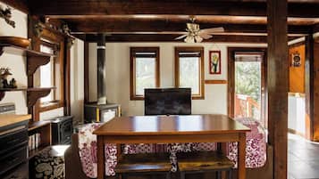 Cozy living room with a fireplace, dining table, and large TV.