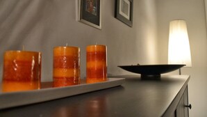 A candle holder with three candles on a table, a lamp, and framed pictures on the wall. - Enchanting Florentine Gem: Perfect Location! (florence)