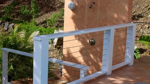 Eine Holzkonstruktion mit einem Metallgitter, umgeben von viel Grün.