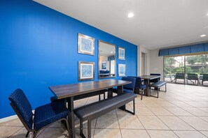 Een eethoek met een blauwe wand, ingelijste foto’s en uitzicht op het landschap.