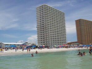 A beachfront hotel with multiple balconies, a sandy beach, and clear blue skies. -  " Awesomeness At Its Best " Beach Front 5th Floor Condo. ( FREE Beach Service) (Panama City Beach)