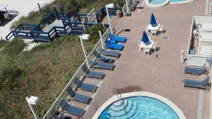 Un resort con piscina, acceso a la playa y zonas de descanso.