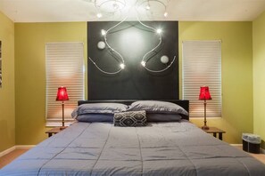 A bedroom with a bed, two bedside lamps, a patterned pillow, and a wall-mounted light fixture. - Quiet desert getaway, ping-pong, BBQ, citrus (Phoenix)