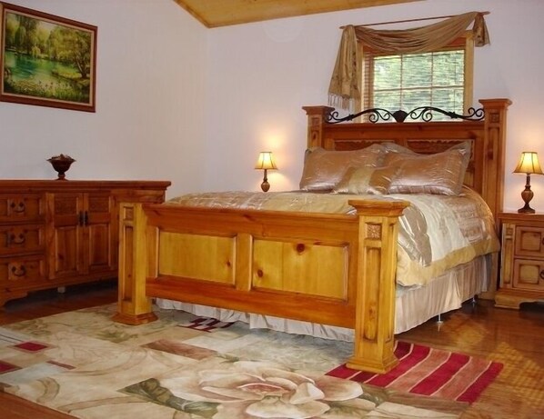 A wooden four-poster bed with a canopy, two bedside lamps, and a floral-patterned rug. - Romantic Mountain Chalet with Stream & Gazebo (Murphy)