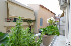 Enjoy the serene view from this balcony with a potted plant and metal railing.