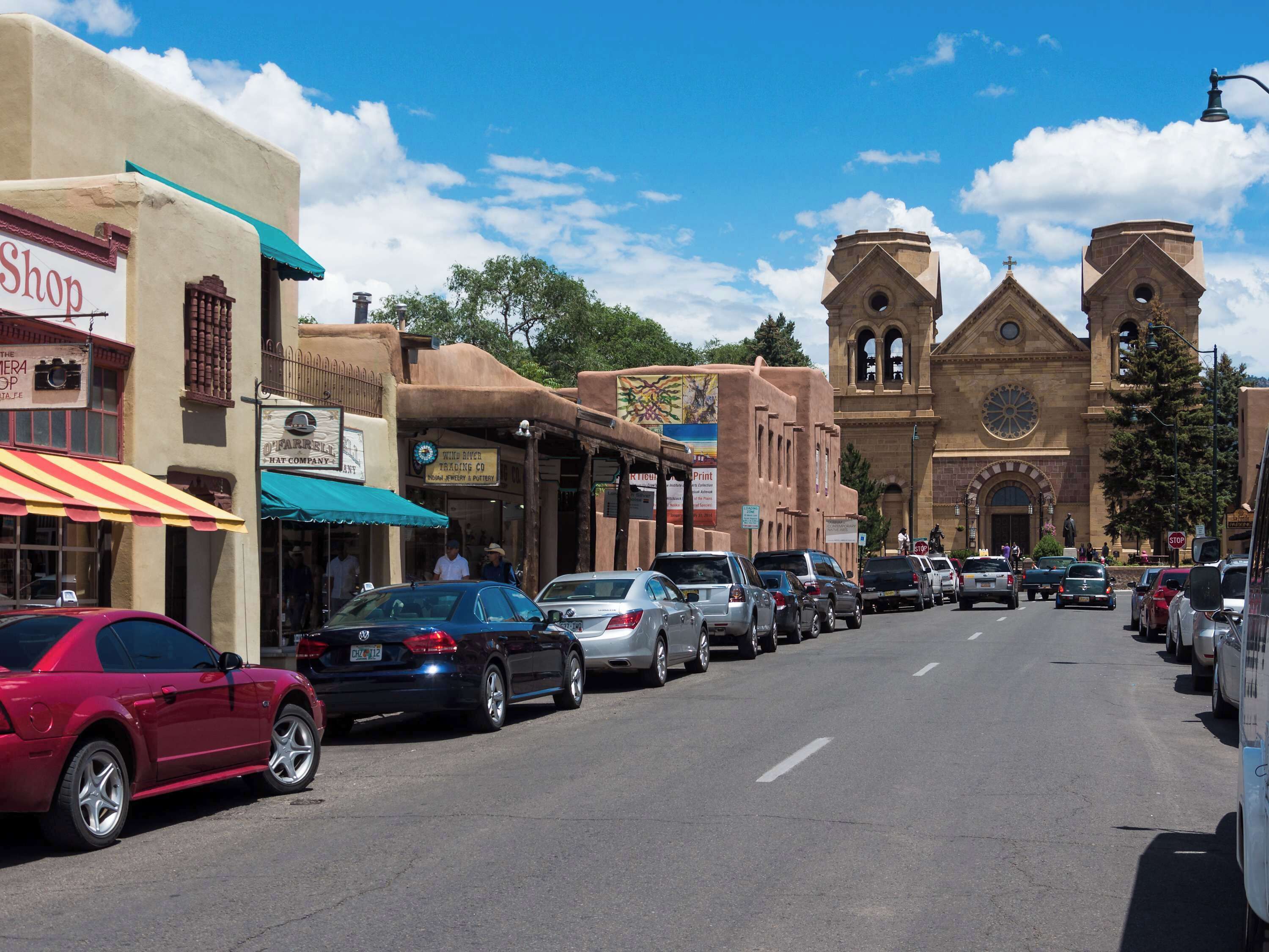 A street lined with shops and a church with a bell tower.