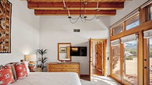 A bedroom with a bed, dresser, TV, and a large sliding glass door leading to a balcony. - Close to Santa Fe Opera, Four Seasons, Pool Access (Santa Fe)