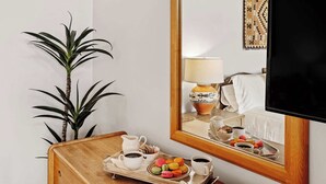 A hotel room with a wooden side table, a potted plant, a tray with coffee and macarons, a lamp, and a TV. - Close to Santa Fe Opera, Four Seasons, Pool Access (Santa Fe)