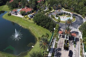 Vista aérea de un complejo turístico con piscina, una glorieta y un lago.