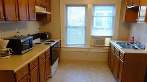 A kitchen with wooden cabinets, a stove, a microwave, and a sink.