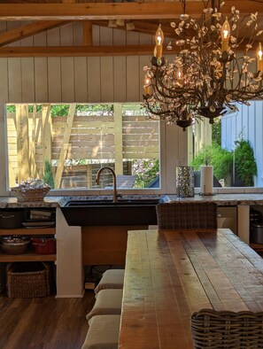 A kitchen with a wooden countertop, a sink, and a chandelier.