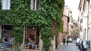 A narrow cobblestone street with a building covered in green ivy. - STUDIO WITH VIEW NEAR THE COLOSSEUM (Roma)