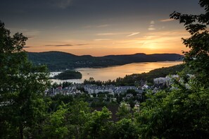 Eine Stadt am Seeufer, mit Gebäuden entlang des Ufers und Hügeln im Hintergrund.