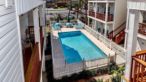 A hotel with a swimming pool, multiple balconies, and a view of the surrounding area. - 🏖️GROUND FLOOR UNIT 🏖SUNSET COTTAGES😎PETS WELCOME🐾
FREEBEACHSERVICE/WI-FI  (Fort Walton Beach)