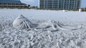 A sandy beach with a large sand sculpture of an octopus and a building in the background. - 🏖️GROUND FLOOR UNIT 🏖SUNSET COTTAGES😎PETS WELCOME🐾
FREEBEACHSERVICE/WI-FI  (Fort Walton Beach)