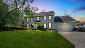 A two-story house with a well-maintained lawn and a garage. - Superb British Colonial holiday home, greenhouse, outdoor deck, tropical garden (Barboursville)