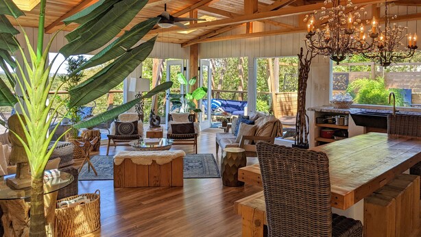 A spacious living area with wooden beams, a chandelier, and large windows. - Parkside INCREDIBLE location-VIEWS-Kayak, SUP, Pool, Gorgeous Hikes-Restaurants (Austin)