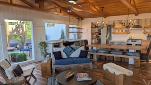 A spacious living area with a wooden ceiling, a sofa set, a coffee table, and a view of the outdoor patio. - Parkside INCREDIBLE location-VIEWS-Kayak, SUP, Pool, Gorgeous Hikes-Restaurants (Austin)