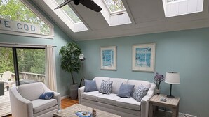 A living room with a sofa, armchair, coffee table, and a potted plant. - Great SUMMER WEEKS Available! (New Seabury)