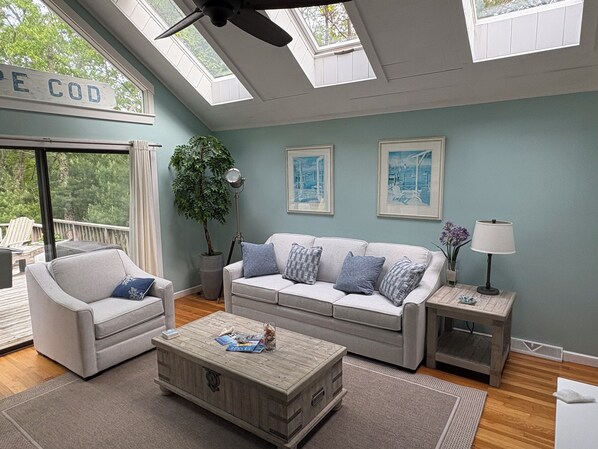 A living room with a sofa, armchair, coffee table, and a potted plant. - Great SUMMER WEEKS Available! (New Seabury)