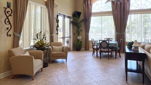 A spacious room with a dining area, two sofas, and a ceiling fan. - LAKEVIEW from Your Private Pool! - Relax & Create Memories - Resort Near Disney! (Davenport)