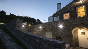 Un edificio de piedra con pared, puerta y ventana de piedra.