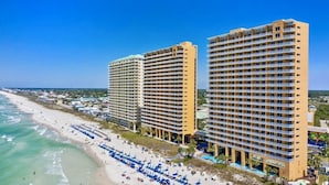 Ein Strandhotel mit mehreren Etagen, einem Pool und Annehmlichkeiten direkt am Strand.