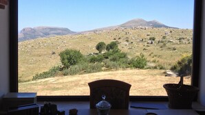 Ein Zimmer mit großem Fenster und Blick auf eine Berglandschaft.