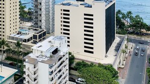 Un hôtel de grande hauteur, avec de nombreux étages, une piscine sur le toit et une vue sur l’océan.