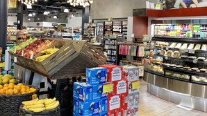 L’intérieur d’une épicerie, avec différents rayons proposant une variété de produits alimentaires, notamment des fruits et légumes frais et des produits emballés.