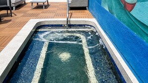 Un espace piscine avec des chaises longues et une fresque murale.