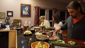 Un'area pranzo con un'impostazione buffet, che include diversi piatti e utensili sul tavolo.