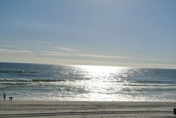 A beach with waves and a clear sky.