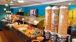 Un área de bufé con diversas opciones de comida, como cereales, frutas y otros bocadillos.