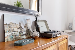 Cozy retreat with a vintage turntable, elegant vase, and cityscape art.
