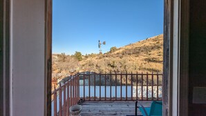 A balcony with a metal railing, a bucket, and a chair. - Great house for making memories! Two living areas, bar, and pool table (Alpine)