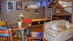 A room with a pool table, a couch, and a neon sign advertising Bud Light. - Great house for making memories! Two living areas, bar, and pool table (Alpine)