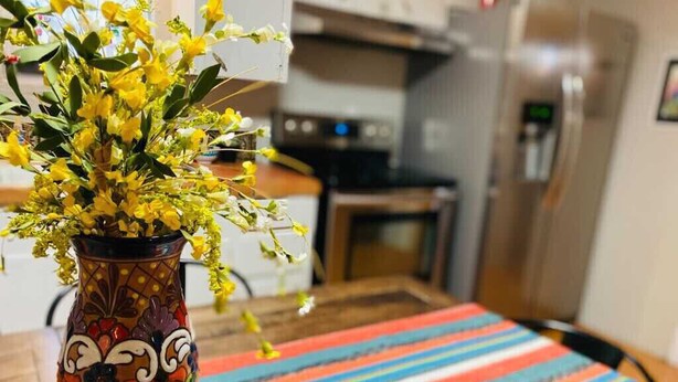 A kitchen with a vase of yellow flowers on a colorful mat. - Great house for making memories! Two living areas, bar, and pool table (Alpine)