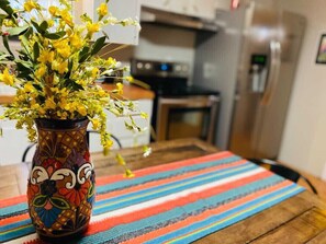 A kitchen with a vase of yellow flowers on a colorful mat. - Great house for making memories! Two living areas, bar, and pool table (Alpine)